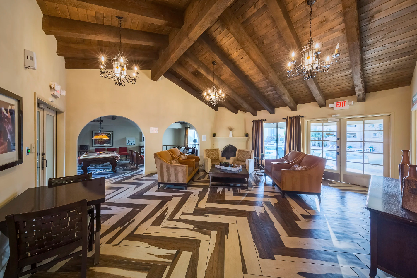 Resident Lounge with Herringbone Flooring,  Exposed Beams on the Ceiling, and Ample Cozy Seating