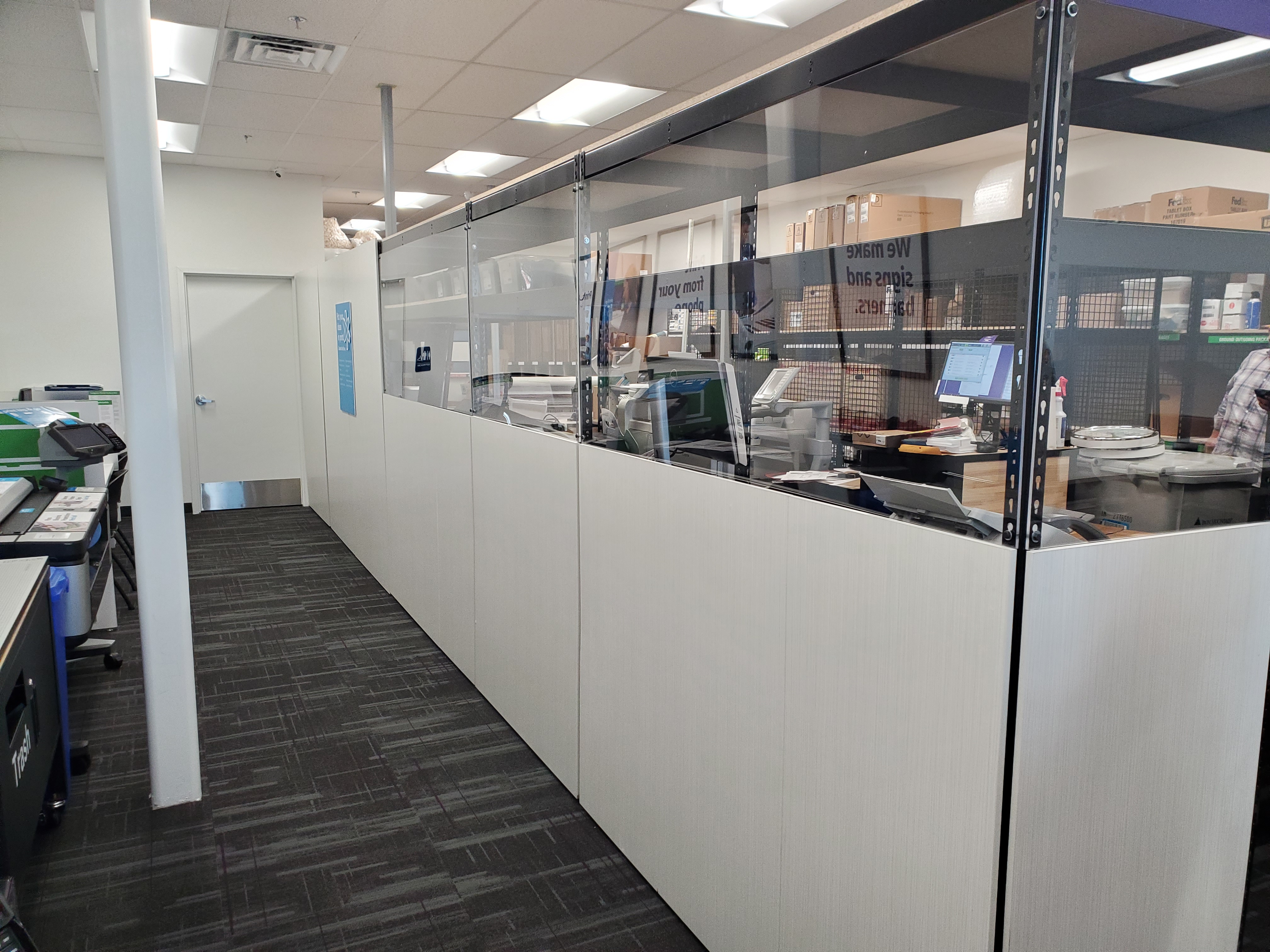 Behind-the-counter production area at FedEx Office College Station Texas where team members handle printing, finishing, and order processing.