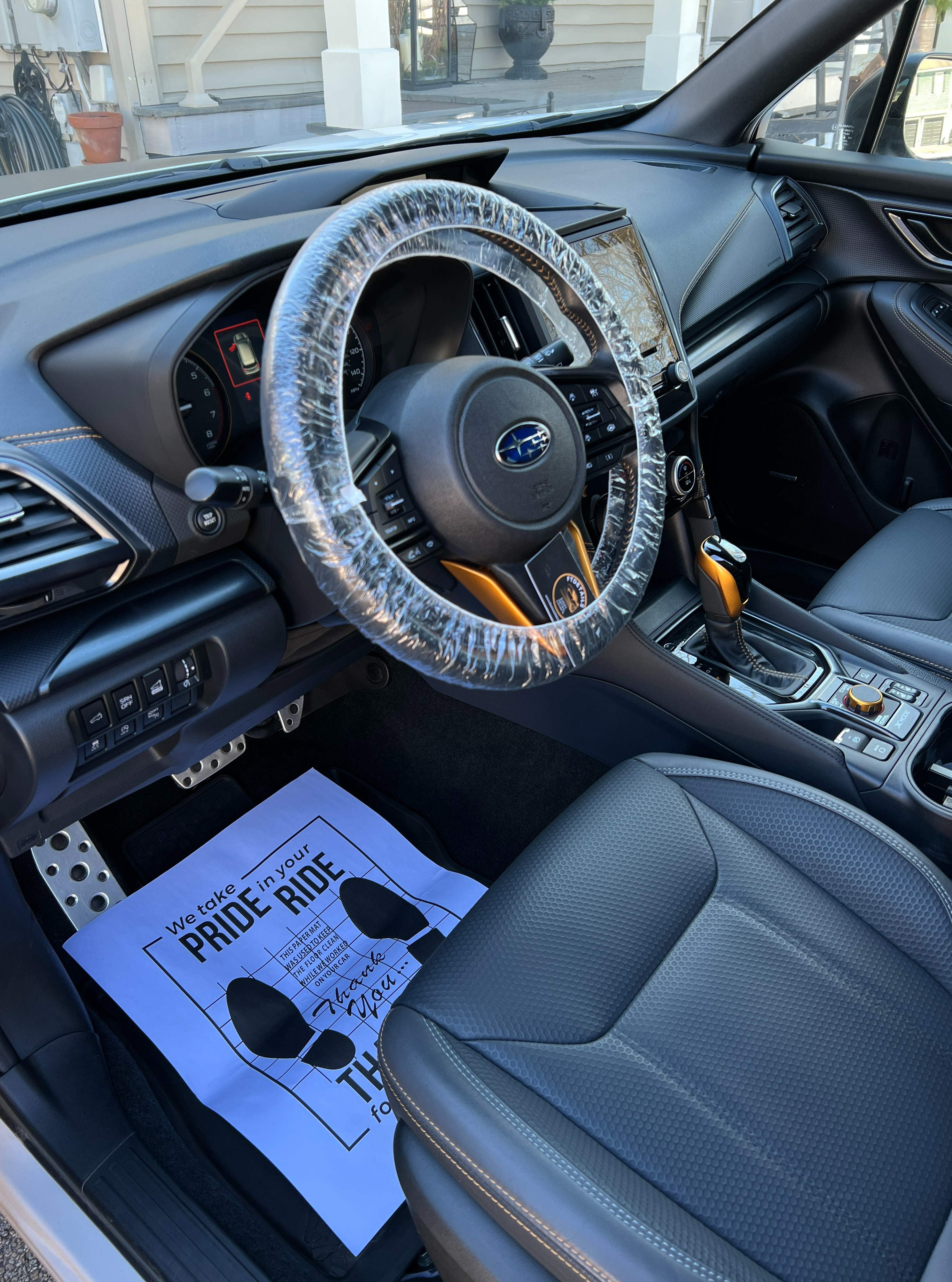 Meticulously cleaned Subaru interior dashboard, seats, and console with protective coverings applied post-detailing.