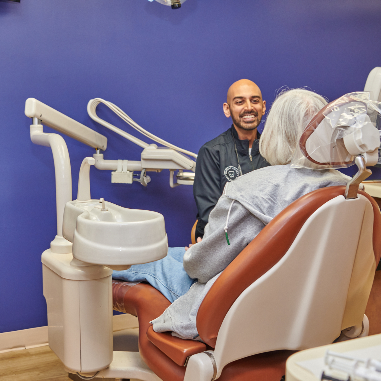 Dr. Jay Patel consulting with a patient in a treatment room at Vibrant Smiles of Holland