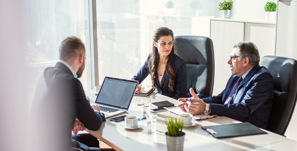 Three people meeting at a table.