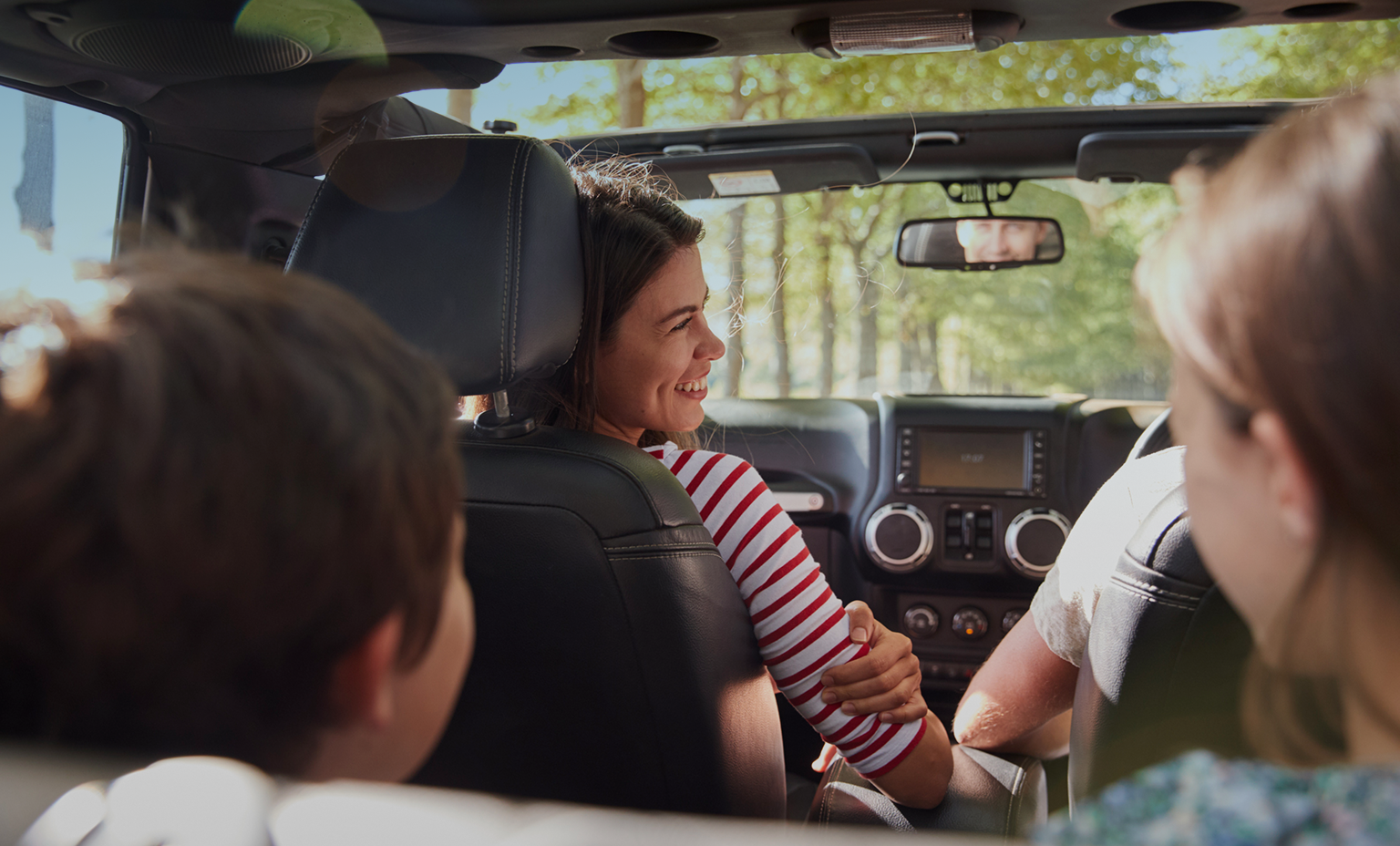 Interior shot of a family in the car on a road trip.