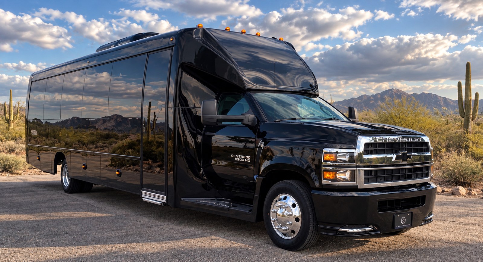 Black executive shuttle bus photographed against the Southern Arizona mountains.