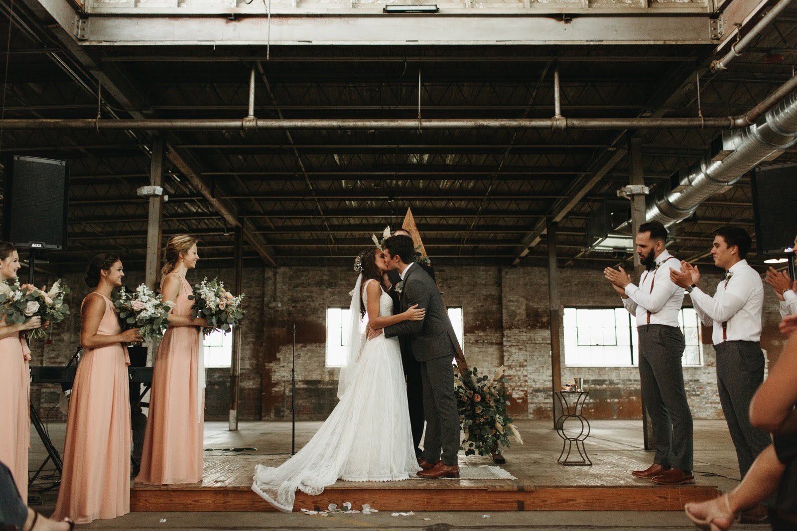 Bride and groom celebrating during their wedding ceremony at The Glass Factory.