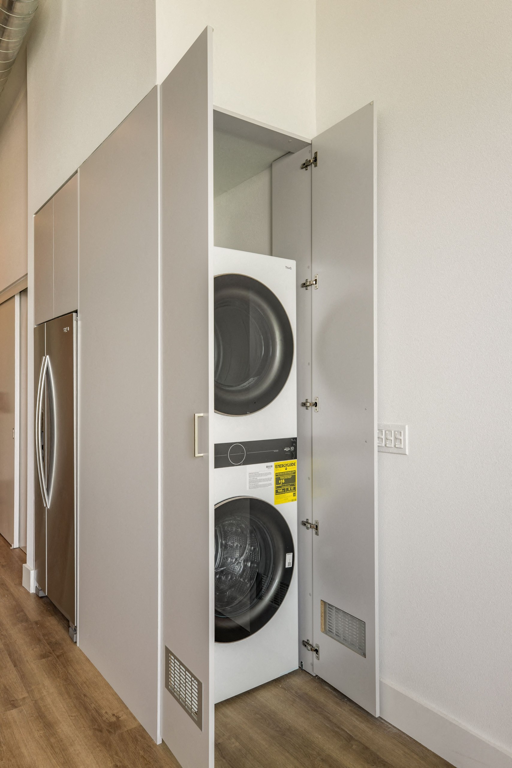 A row of white washing machines in a laundry room.