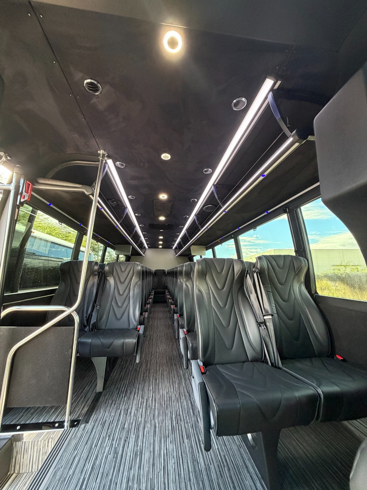Open shuttle interior with perimeter-style passenger seating.