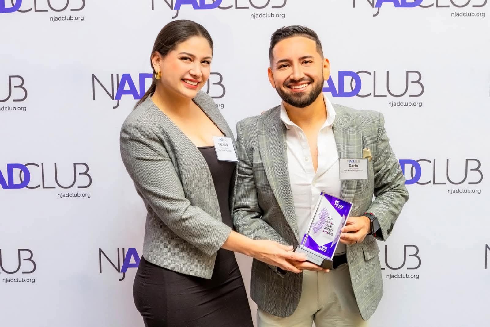 One Marketing Group representative receiving an award at a business networking event.