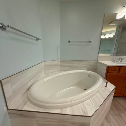 Modern glass-enclosed shower finished with neutral large-format wall tile. 