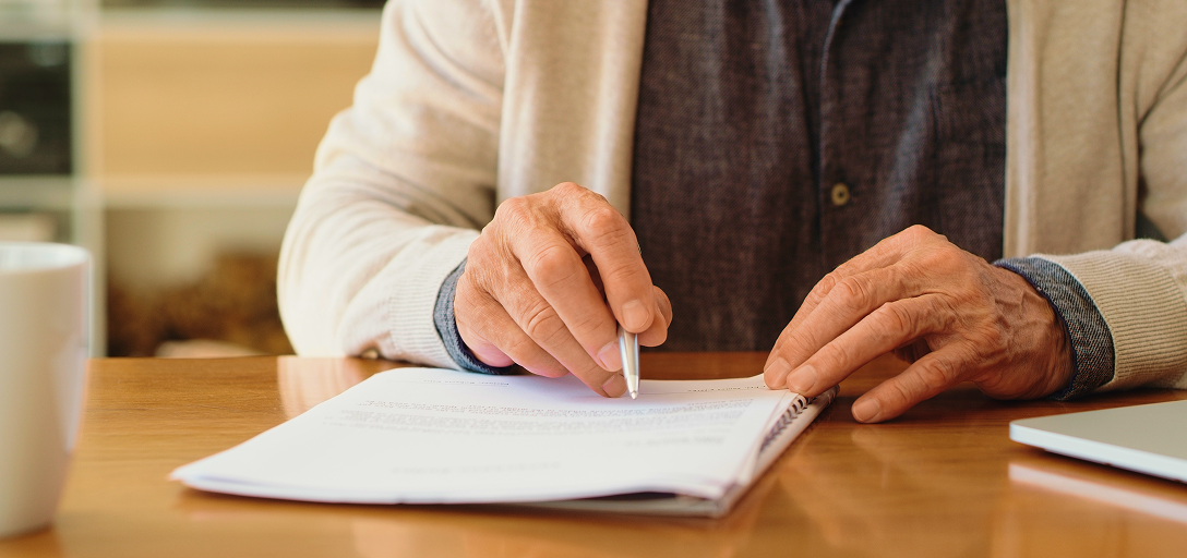 A retired person looking over a statement.