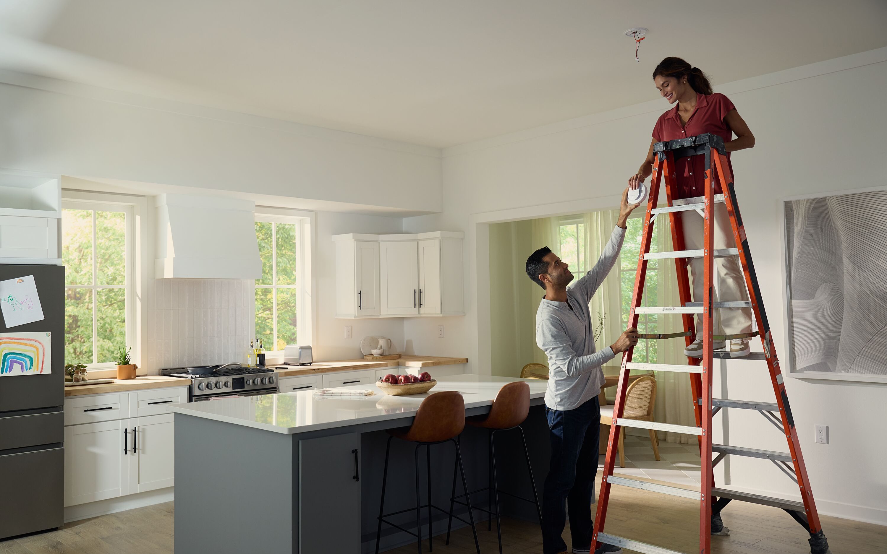 couple installing a carbon monoxide detector