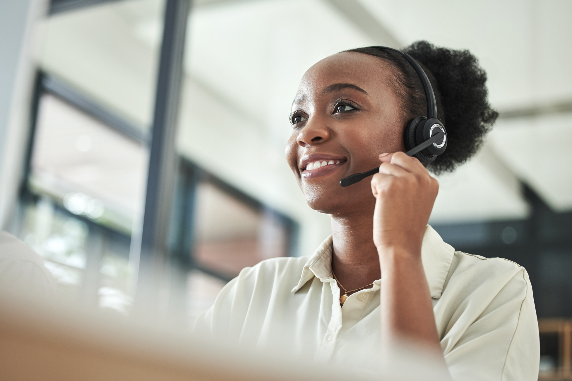 Image of a woman answering the phone with a headset.