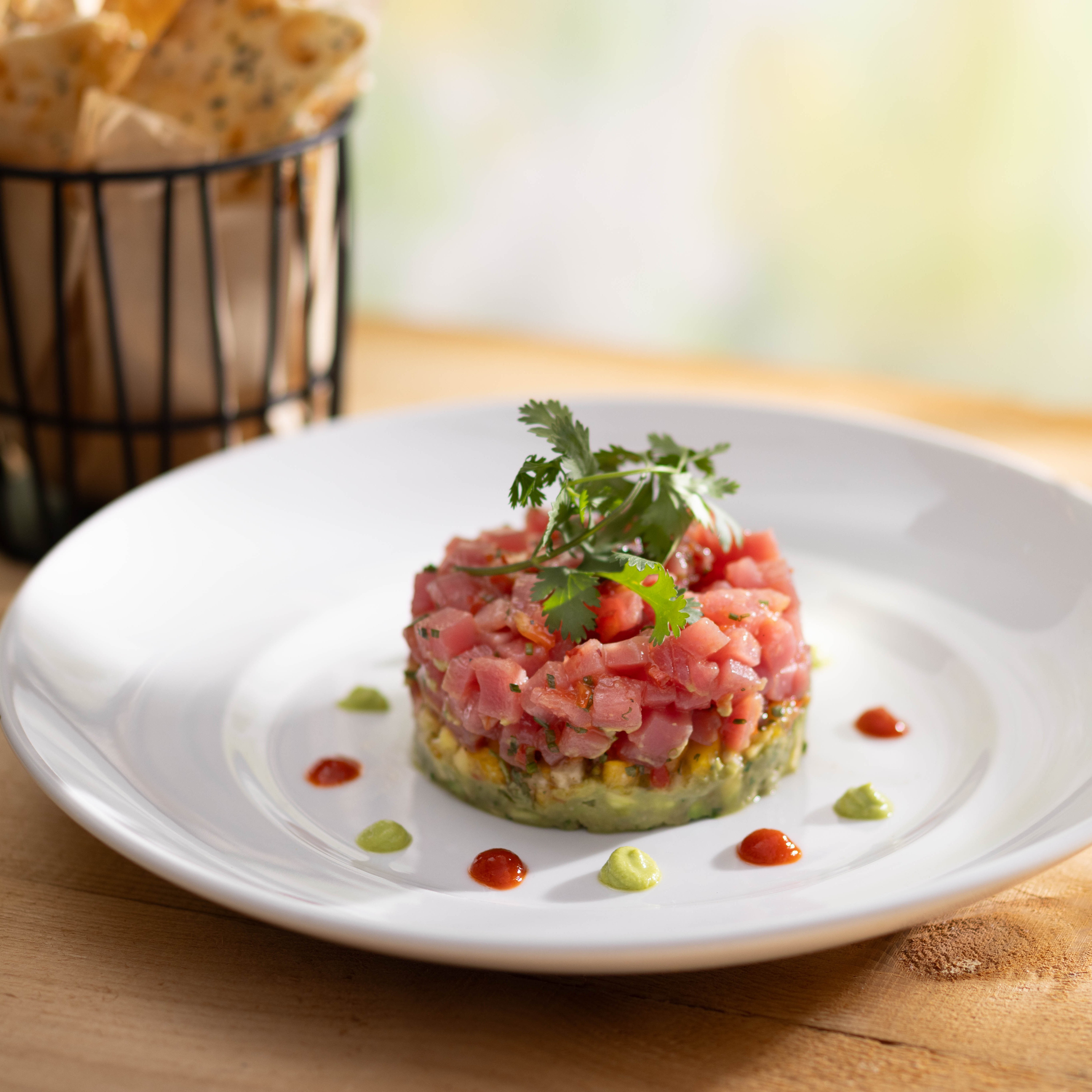 Ahi Tuna Tartare features layers of handline tuna, avocado, tropical salsa, sriracha and wasabi.