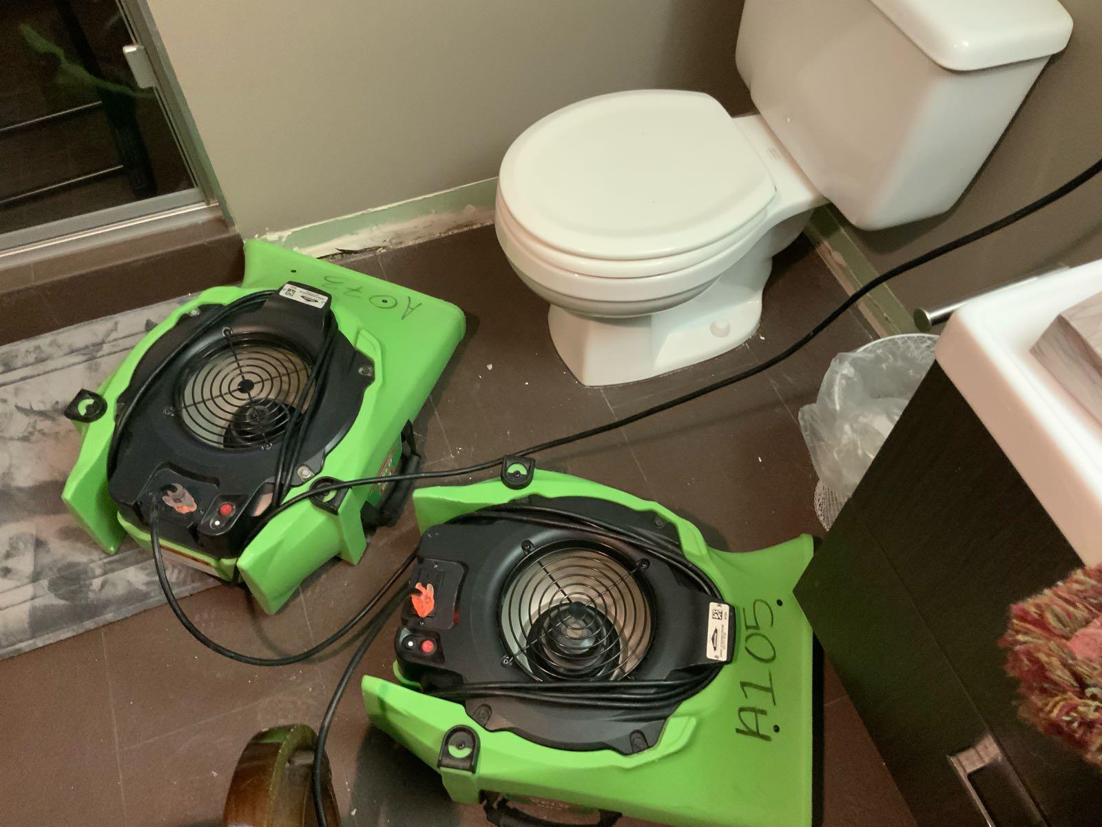 Two green air movers in a bathroom .