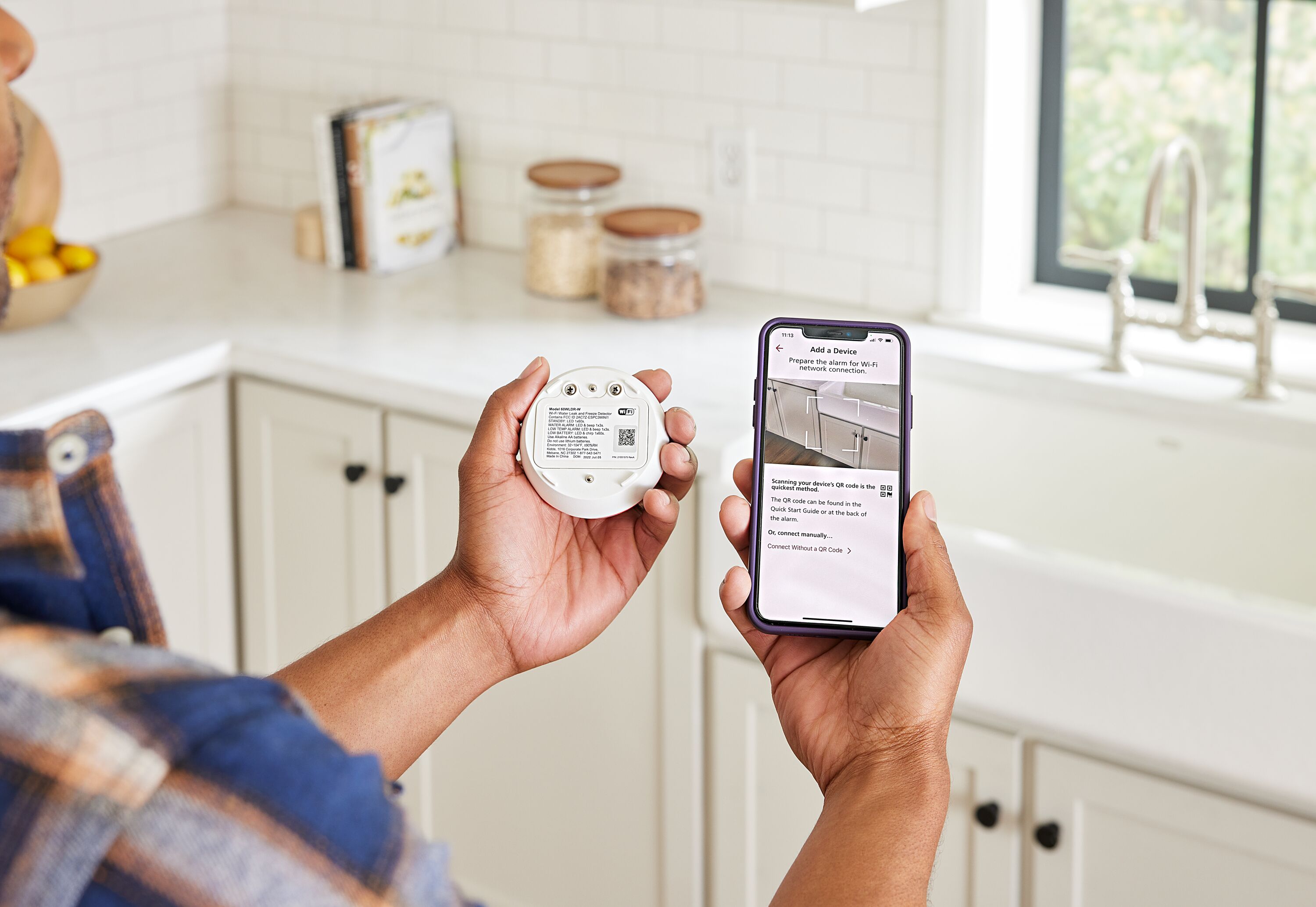A man connects his phone to the Kidde Water Leak and Freeze Detector