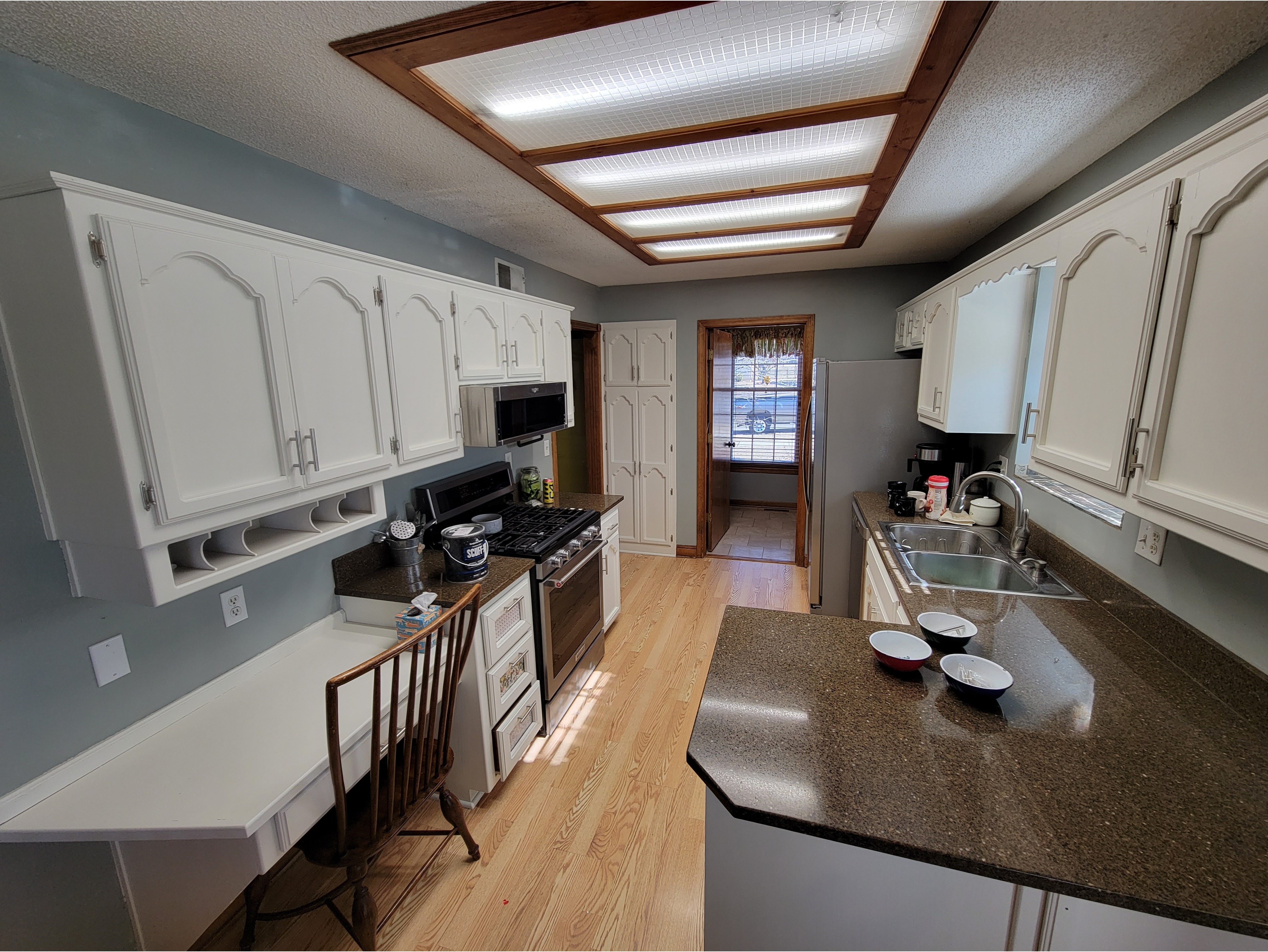 A modern kitchen featuring freshly painted white cabinets with a smooth, clean finish for a bright and updated look. Ideal for highlighting kitchen cabinet painting and refinishing services that transform outdated cabinetry into a fresh, modern design.