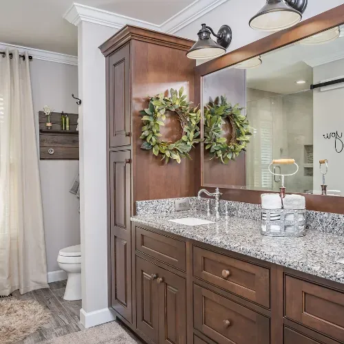 Luxury bathroom remodel in Central North Carolina featuring custom wood cabinetry, stone countertops, and a walk-in shower. This project highlights premium materials and expert craftsmanship from a trusted residential remodeling contractor.