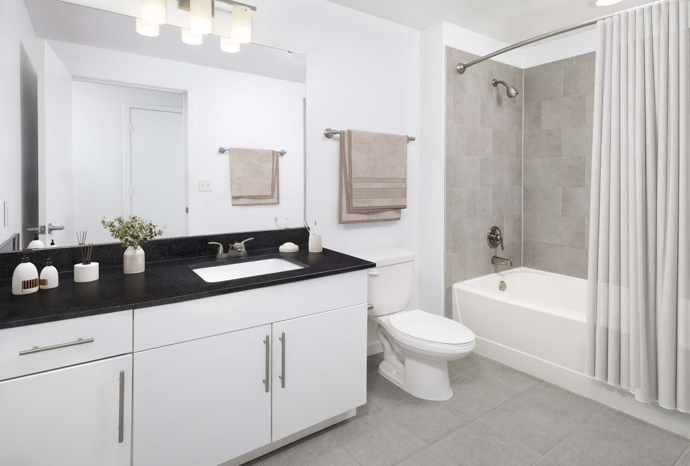Apartment home bathroom with granite countertops and shower-tub combo at Camden Thornton Park apartments in Orlando, FL.