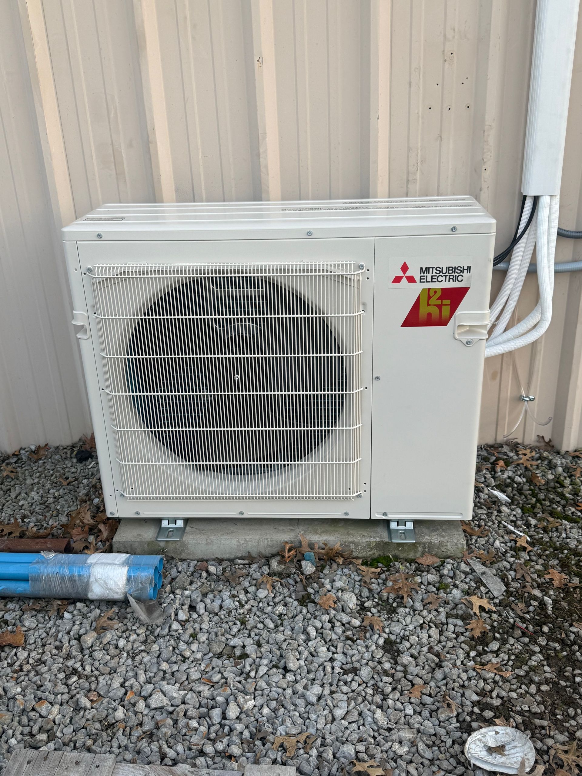 Mitsubishi Electric outdoor mini split condenser shown from the front, featuring a large fan grille, 