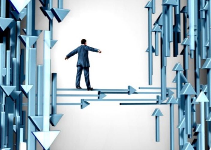 Graphic of a suited man balancing on a beam made of arrows.