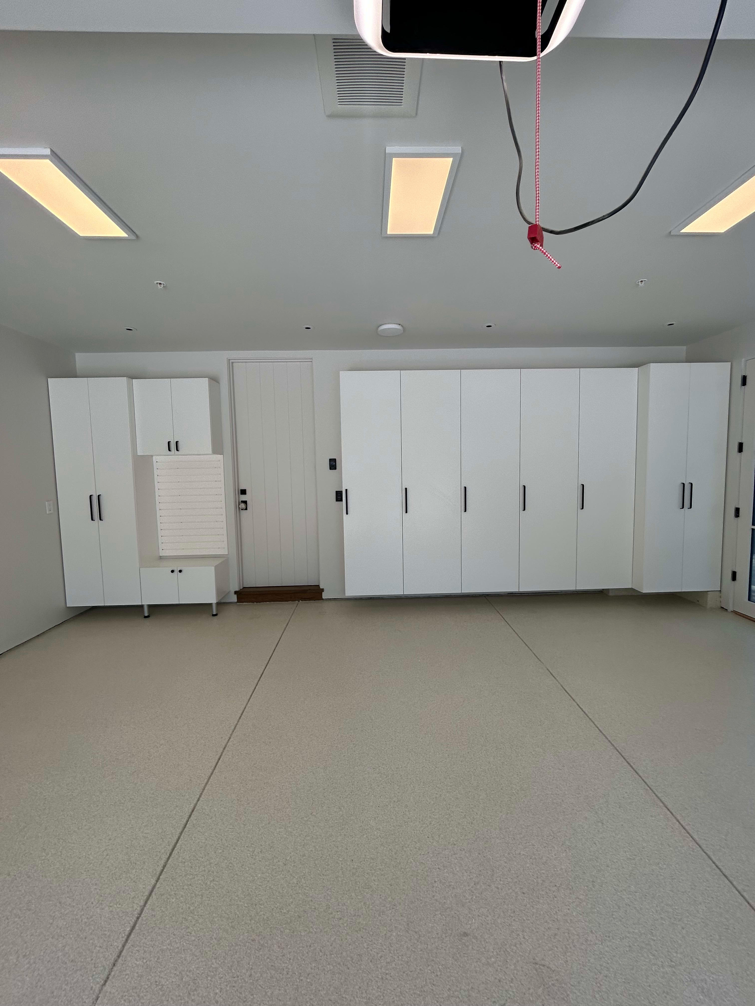 White Cabinets, white slatwall, custom epoxy flooring by Premier Garage of the Bay Area