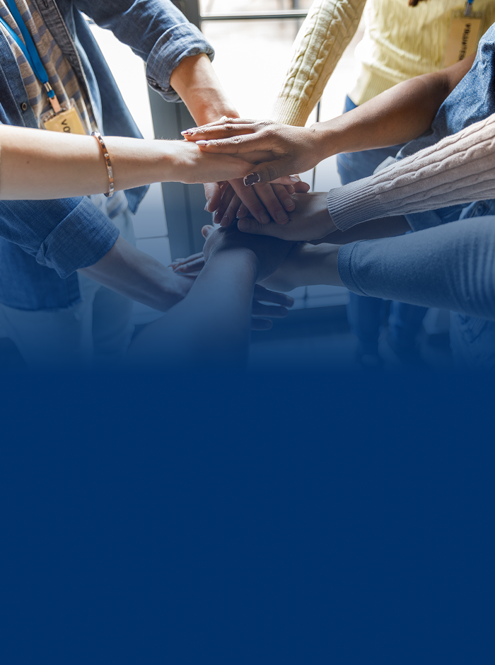 A close up of a bunch of volunteers performing a team hand-stack.