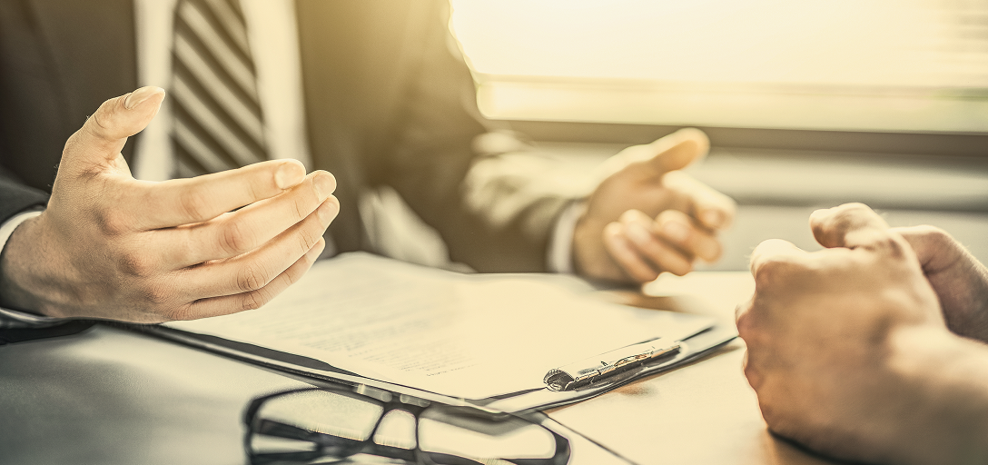 Close-up of two people having a conversation in an office.