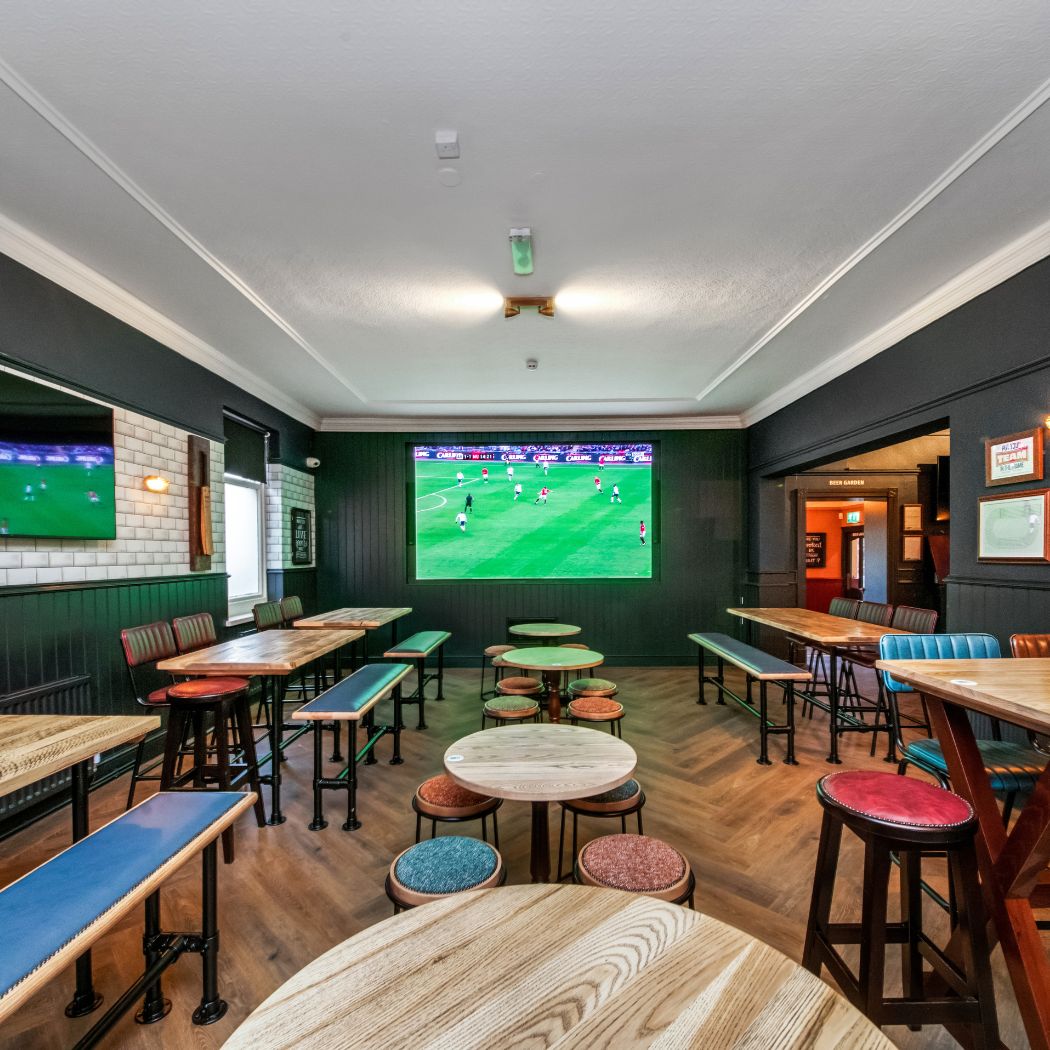 Dedicated sports viewing area with multiple screens and flexible seating, perfect for watching live matches.