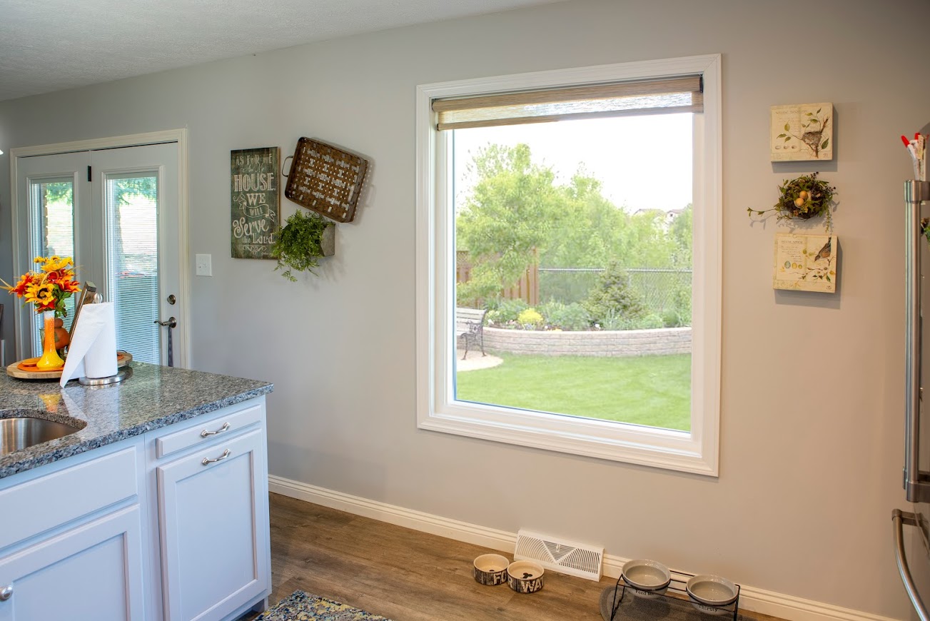 The EcoTek 3200 Series Picture Window in this kitchen provides a clear view of the outdoor garden, filling the space with natural light. Its sleek design adds a modern touch to the cozy, farmhouse-style decor, creating a bright, welcoming atmosphere that enhances the connection to nature.