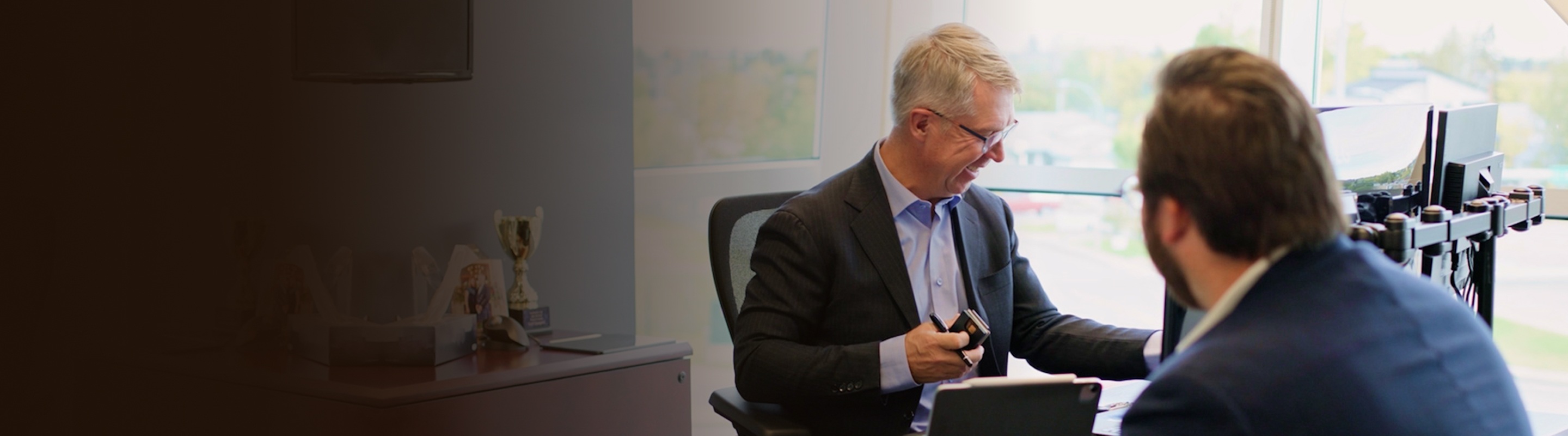 Kevin Chrenek and Tyson Beaupre in discussion in an office.