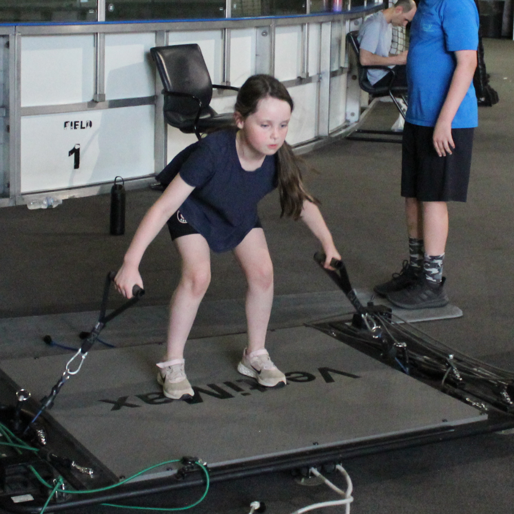 Youth female athlete performing VertiMax jump training at Impact Sports Performance