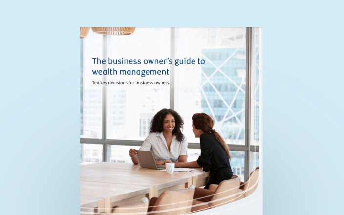 Cover of the business owner's guide with two professionals at a board room table.