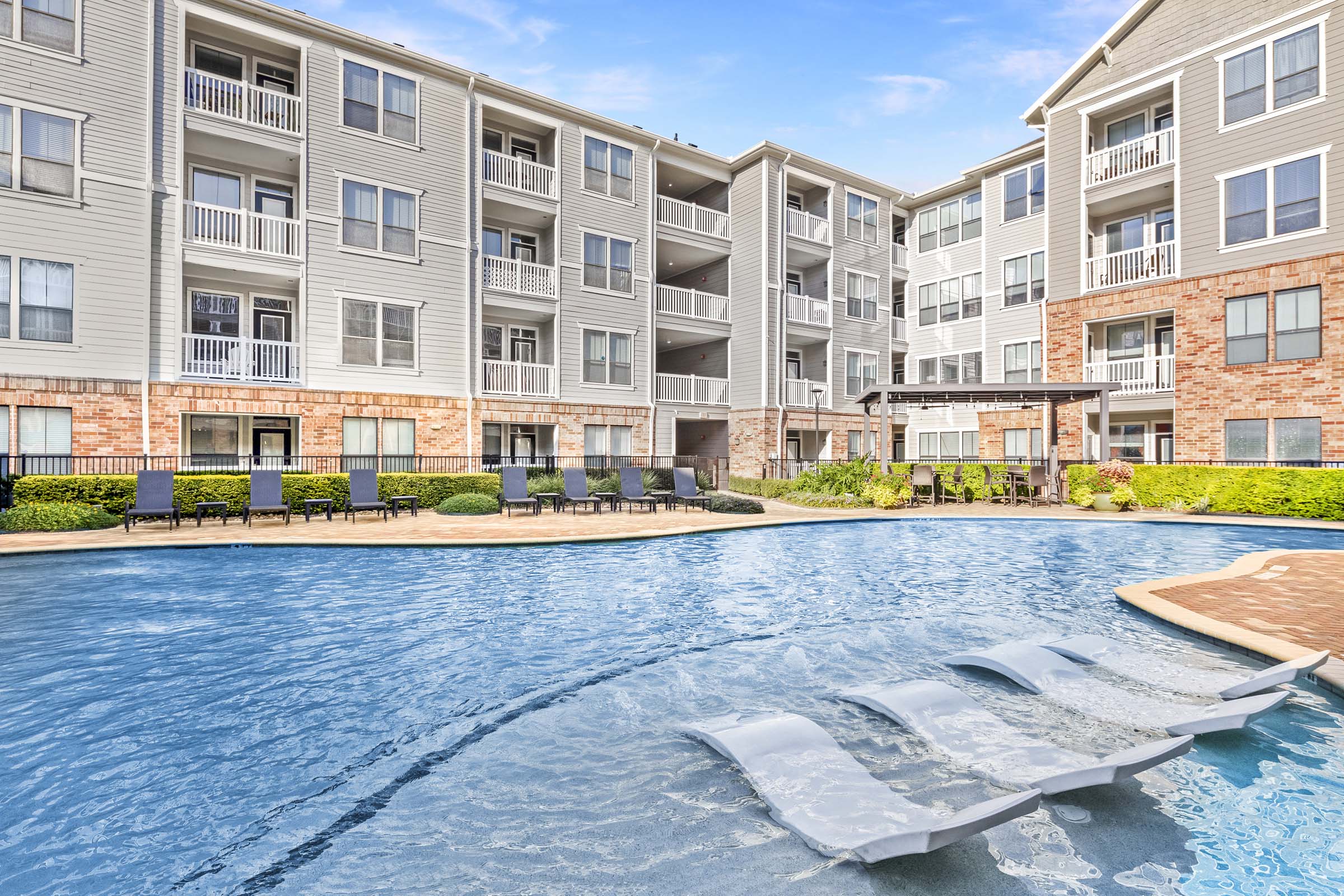 Resort-style swimming pool with water features and sun loungers at Camden Heights Apartments in Houston, TX