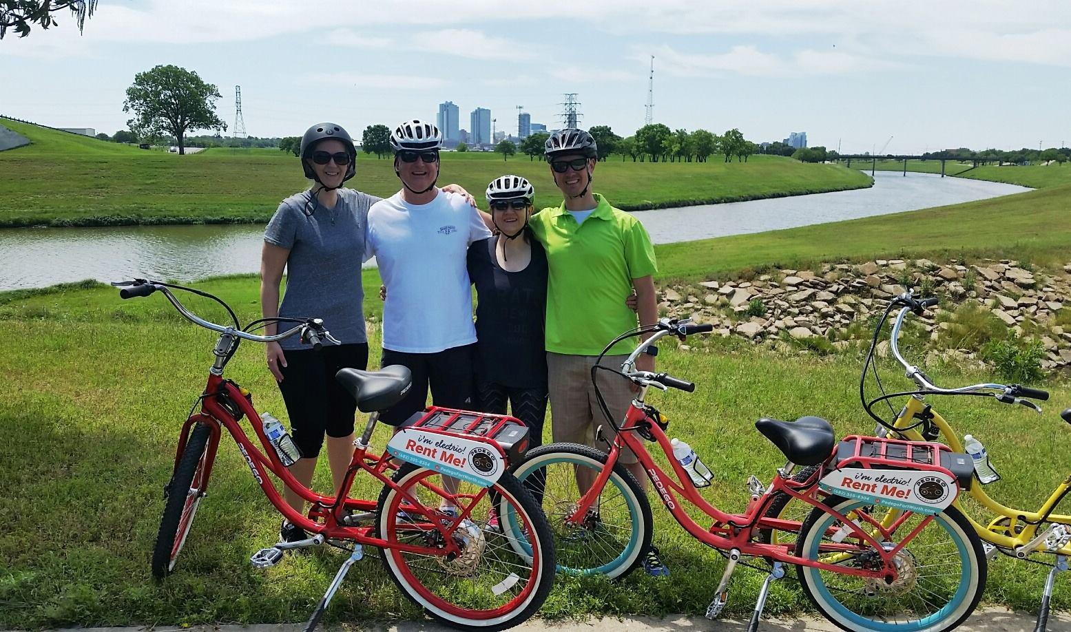 family posing in front of their Pedego rentals