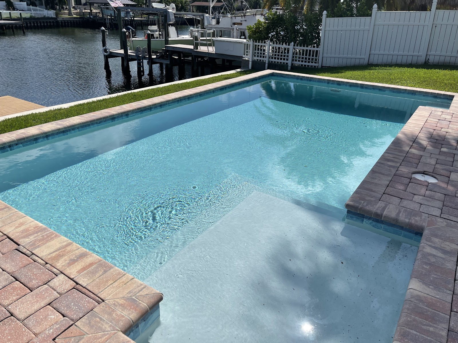 Waterfront residential swimming pool with a shallow sun shelf, brick paver decking, and scenic canal views.
Select 84 more words to run Humanizer.