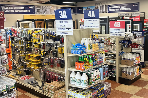 Builders FirstSource New Bedford hardware section with organized displays of fasteners, screws, and power tool accessories.