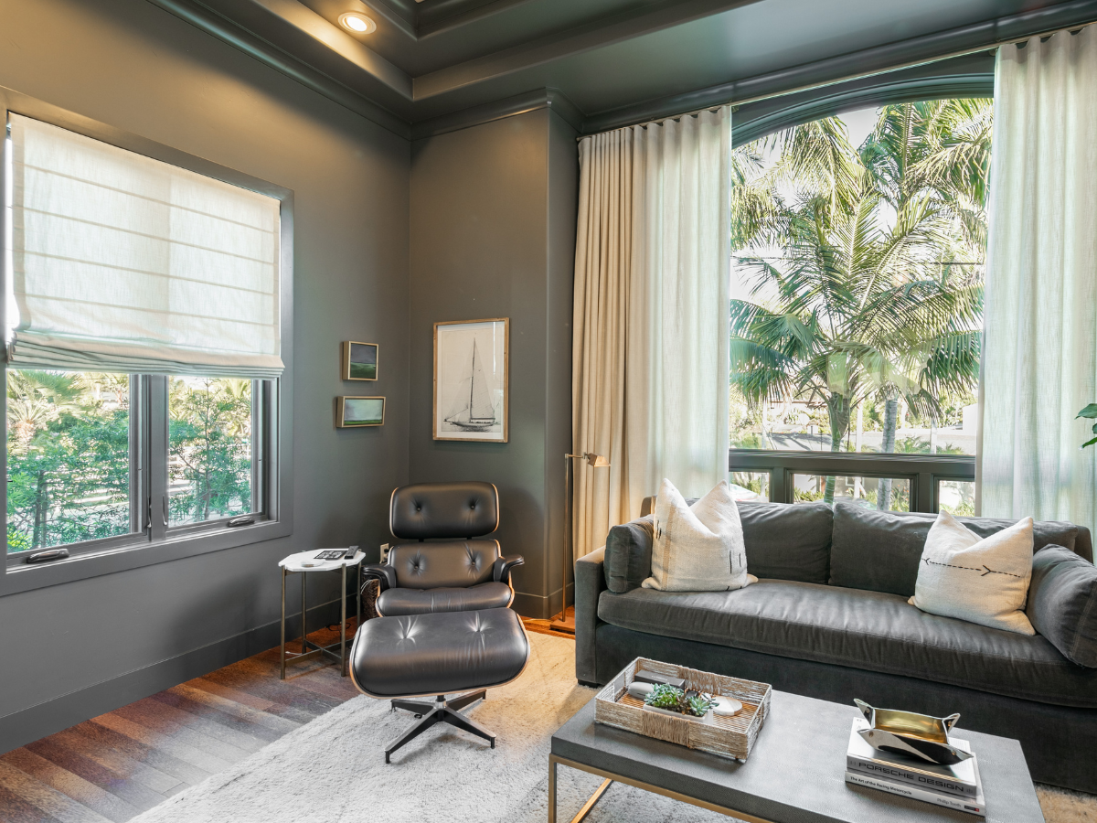 Layered textures and soft, flowing drapery with a structured Roman shade create a cozy yet refined look in this space.