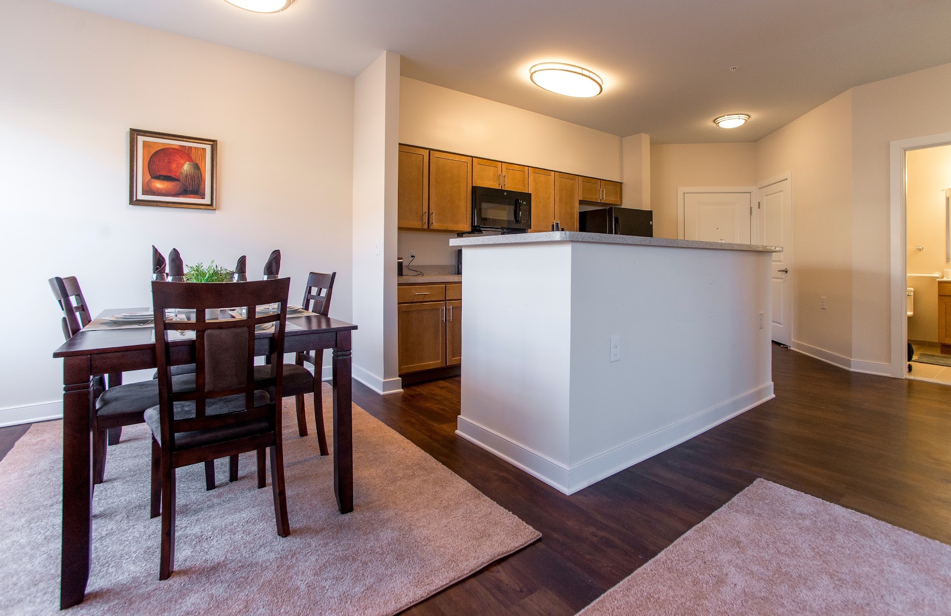 A dining room with a white island and wooden chairs