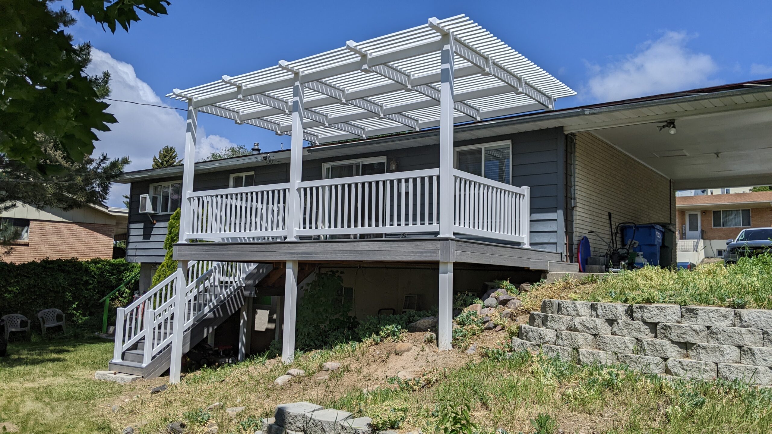 Expand your outdoor living possibilities with this custom deck by DeckPro LLC, which combines rustic elements with modern materials. We installed low-maintenance composite decking in a warm brown tone and paired it with a unique railing system that features natural wood posts and integrated wire mesh infill panels. For the ultimate in functional design, we included extensive built-in L-shaped bench seating, creating a cozy and inviting perimeter perfect for taking in scenic views.