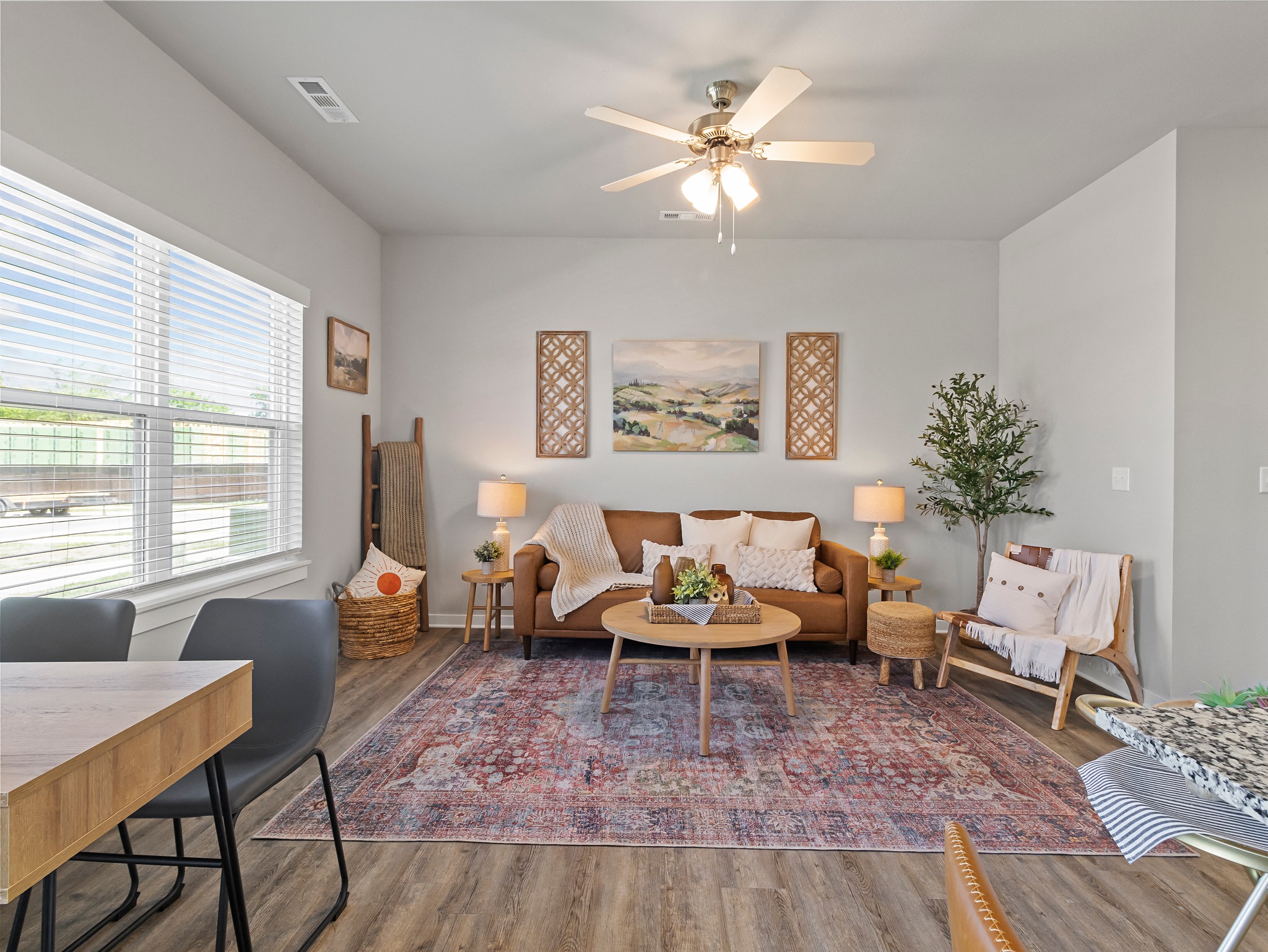 a living room with couches and a table and a ceiling fan