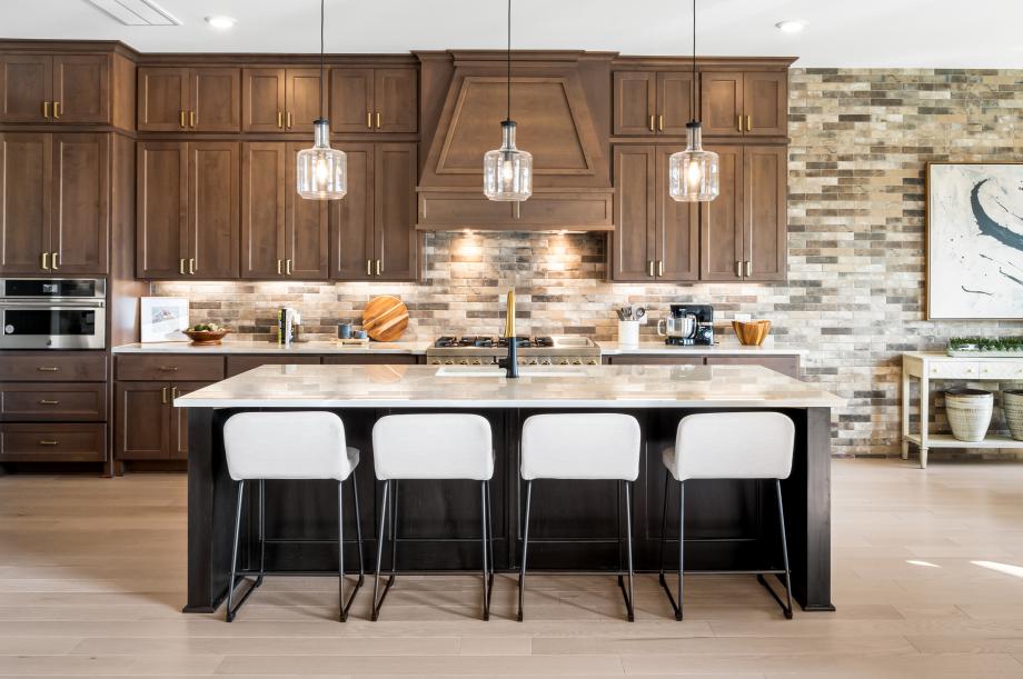 Chef-inspired kitchen with premium stainless steel appliances, expansive island and full-height backsplash