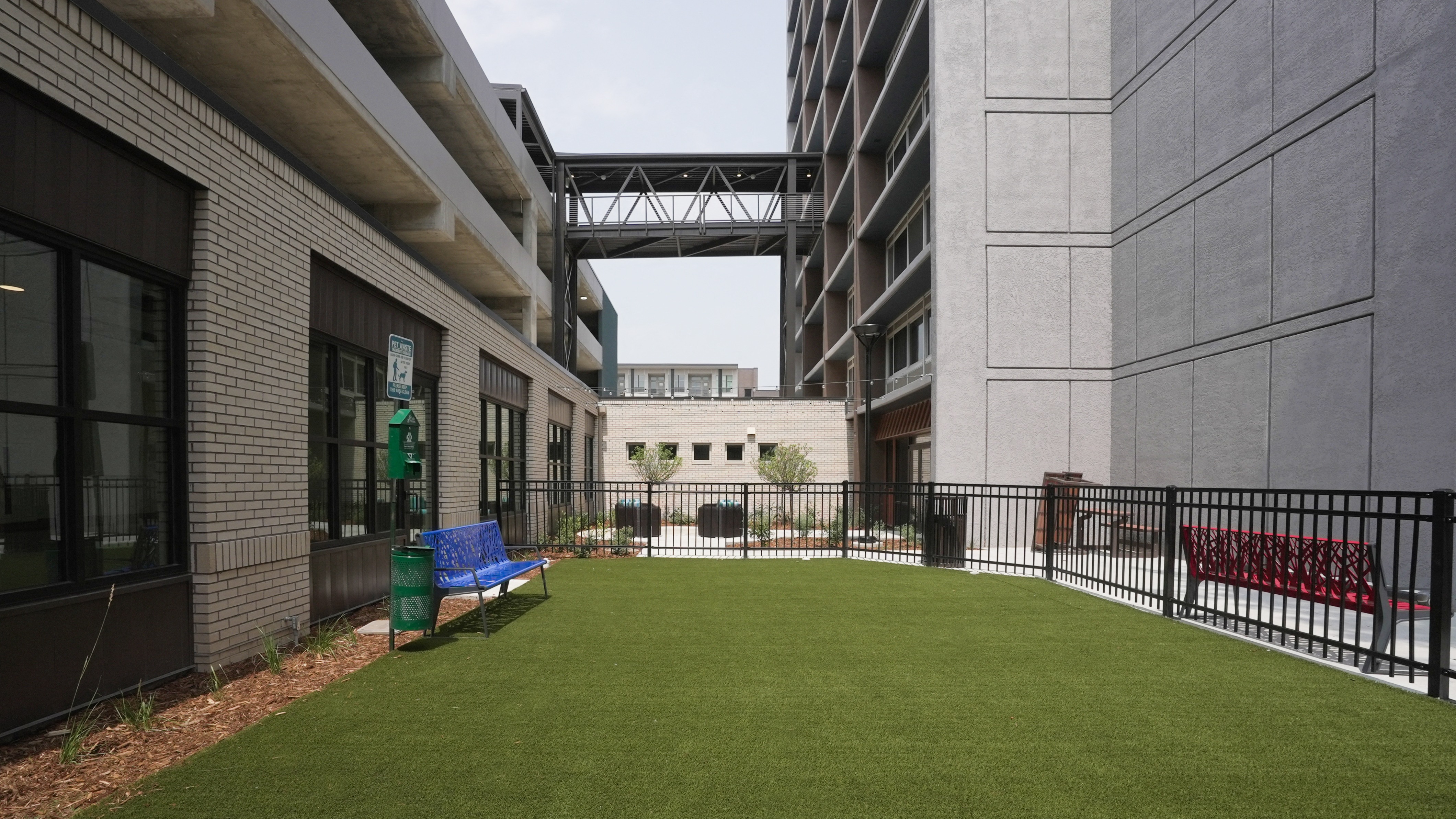 A small grassy area with a bench in front of a building.