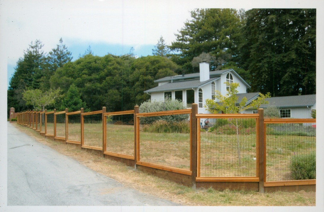 Post and rail wood fence installation surrounding a large property while maintaining an open and natural appearance.