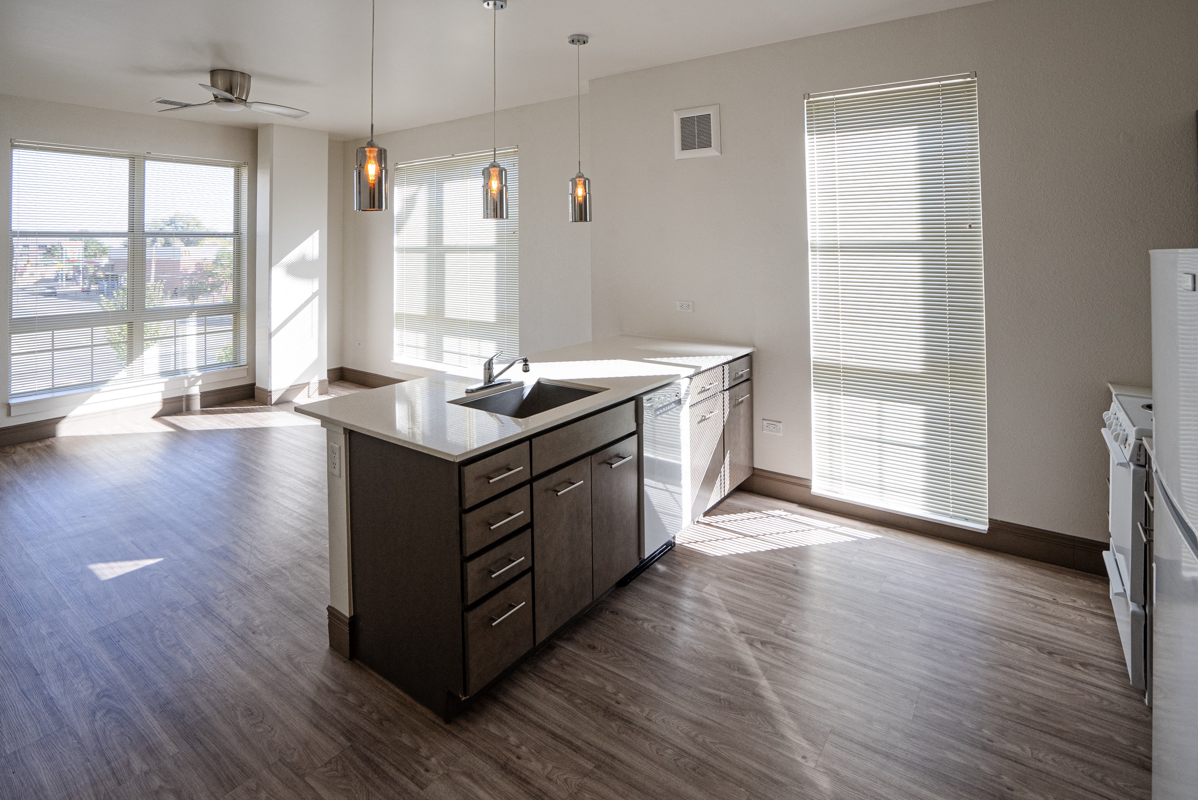 A kitchen with a large island and a fan.