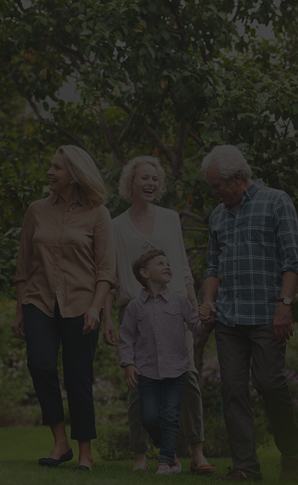 A multigenerational family walking through a garden.