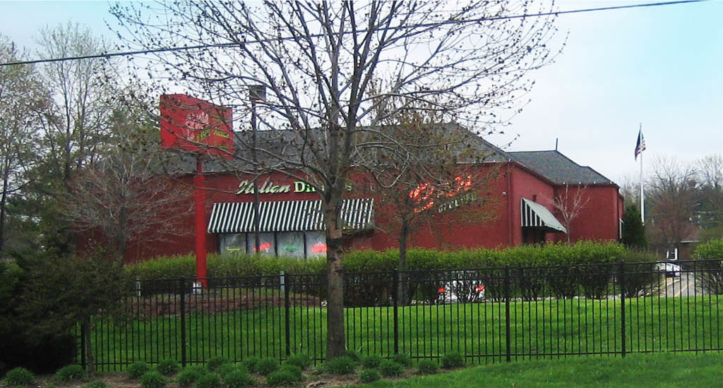 Street View of Buca di Beppo Worthington showing a Buca road sign, a fence, and greenery around the restaurant.