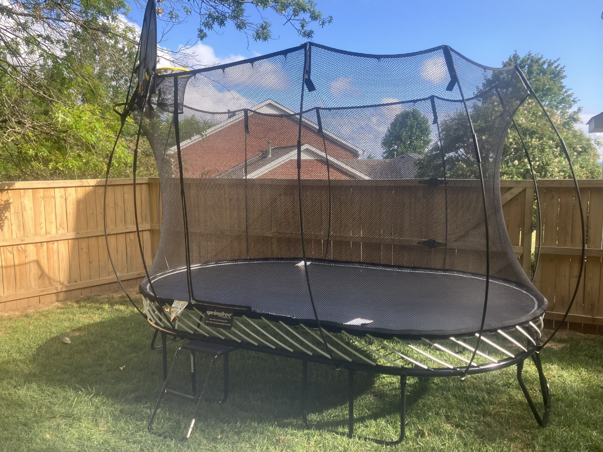 Springfree Trampoline in a fenced backyard.
