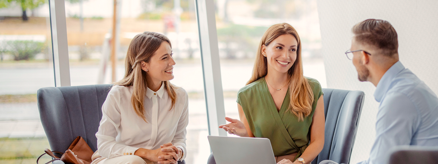 An advisor smiling during a meeting with a client couple.