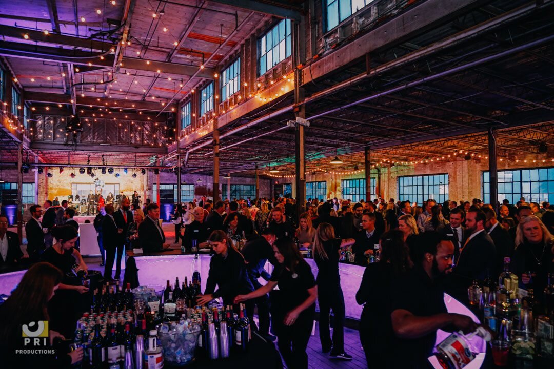 Expansive industrial event space set up for a large reception or corporate gathering.