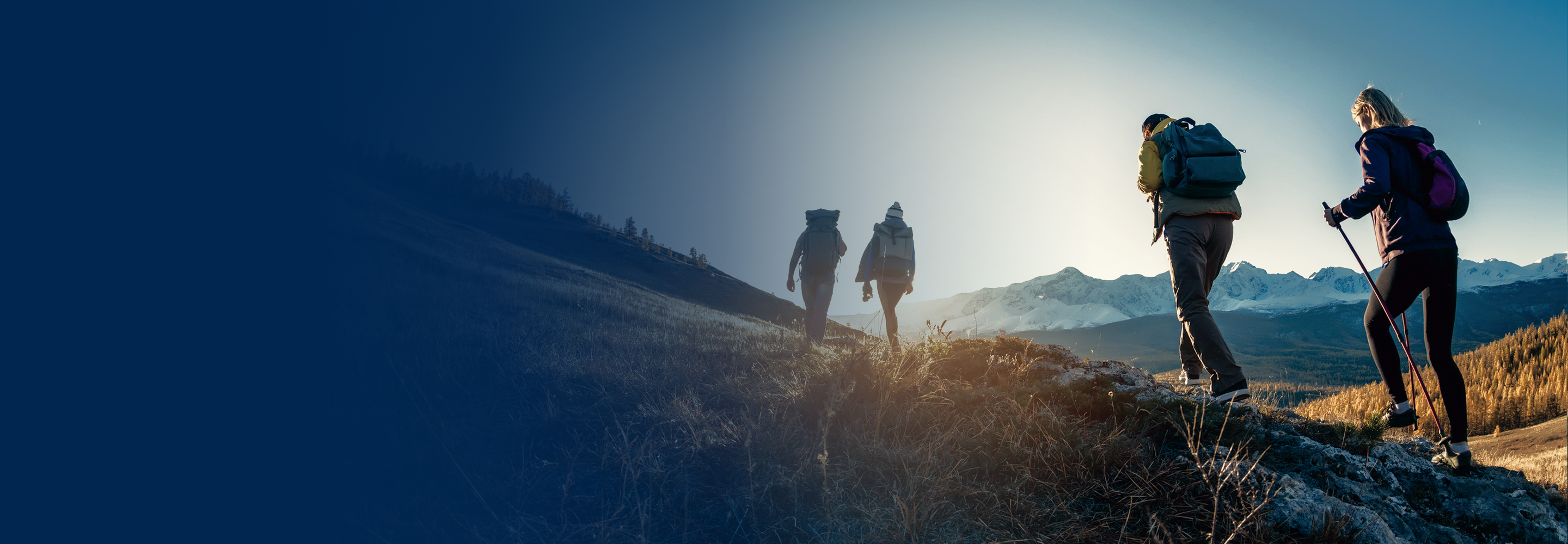 A group on a scenic hike with mountains in the background.