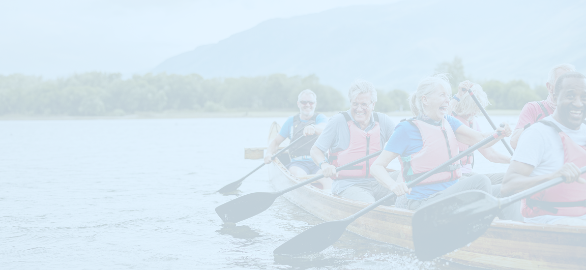 A group of friends paddling together in a large canoe.